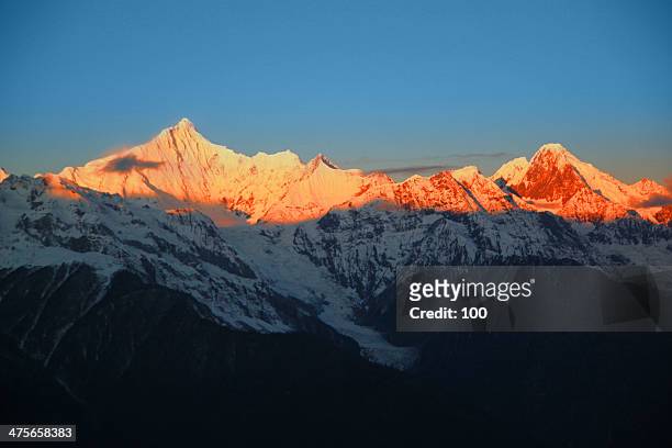 sunrise on the snow mountain peak - alpenglow stock-fotos und bilder