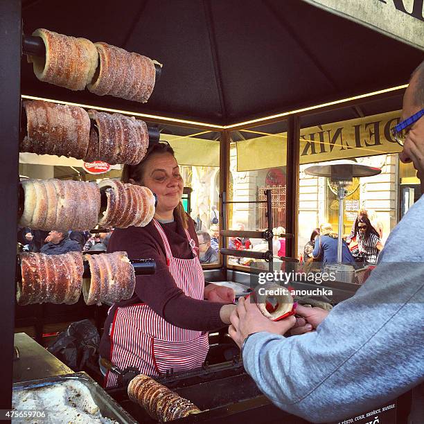 man buying trdelnik, traditional slovac cake in prague - trdelník stock pictures, royalty-free photos & images