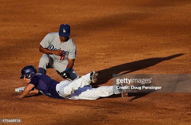 Nick Hundley of the Colorado Rockies dives safely back to second base as shortstop Jimmy Rollins of the Los Angeles Dodgers takes a late pick off...