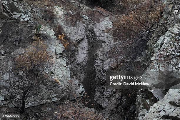 An ash-filled waterfall flows in the Colby Fire burn area as a storm brings rain in the midst of record drought on February 28, 2014 near Azusa,...