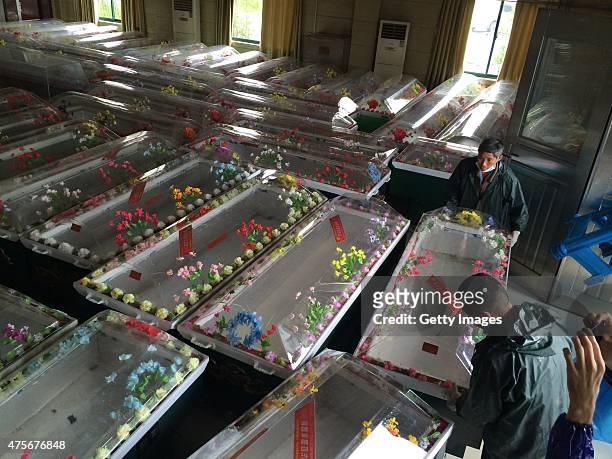 Workers prepare coffins for victims from the capsized ship Dongfangzhixing at a funeral parlour on June 3, 2015 in Jingzhou, China. A passenger ship...