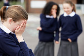Female Elementary School Pupils Whispering In Playground