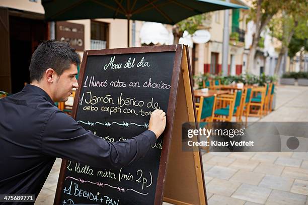waiter writing sign with traditional tapas dishes - tarde imagens e fotografias de stock