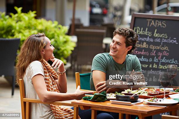 couple laughing together at restaurant - cafe table chair outside ストックフォトと画像