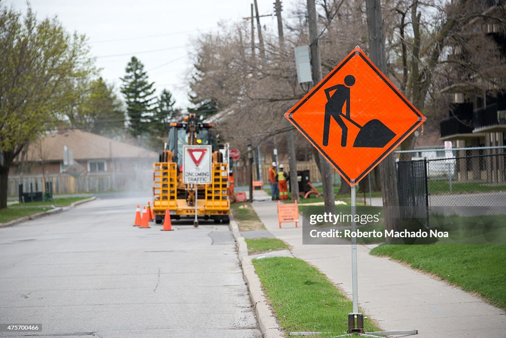 Bright orange traffic sign warns of construction ahead with...