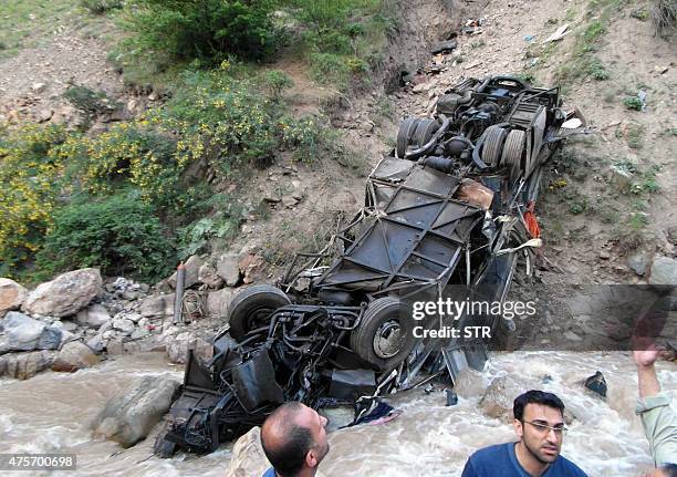 Iranian authorities inspect the site of an accident with a tourist bus that plunged off a mountain road into a valley in northern Iran on June 2...
