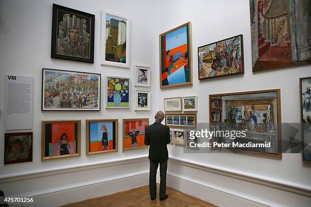 Visitor looks at paintings in the Summer Exhibition at The Royal Academy on June 3, 2015 in London, England. The RA Summer exhibition is the world's...