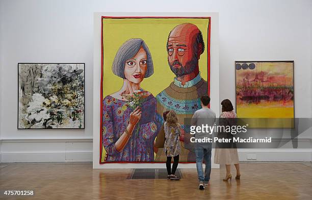 Visitors look at a tapestry by artist Grayson Perry called 'Julie and Rob' in the Summer Exhibition at The Royal Academy on June 3, 2015 in London,...