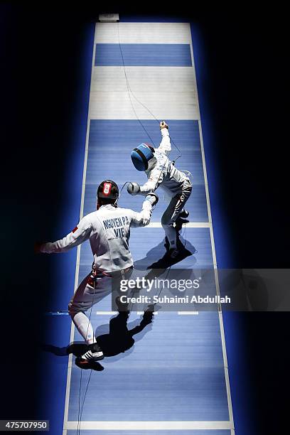 Nguyen Phuoc Den of Vietnam competes against Lee Mun Hou Samson of Singapore during the men's individual epee quarterfinals match at OCBC Arena Hall...