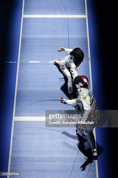 Rihandini Verdiana of Indonesia competes against Wong Mae Hui Shan Nicole of Singapore during the women's individual foil round of 16 at OCBC Arena...