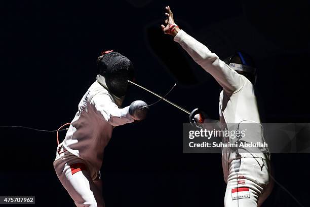 Nguyen Tien Nhat of Vietnam competes against Muhammad Haerullah of Indonesia in the men's individual epee quarterfinals match at OCBC Arena Hall...