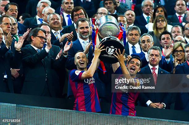 Barcelona players Andres Iniesta and Xavi Hernandez of FC Barcelona celebrate with the trophy after winning the Copa del Rey Final match between FC...