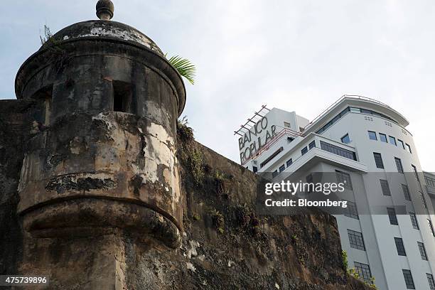 The Banco Popular building, right, stands near a section of the wall that surrounds Old San Juan, Puerto Rico, on Friday May 29, 2015. For the hedge...