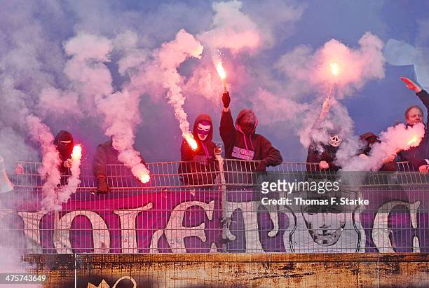 Supporters of Osnabrueck fire smoke bombs during the Third League match between Preussen Muenster and VfL Osnabrueck at Preussenstadion on March 1,...