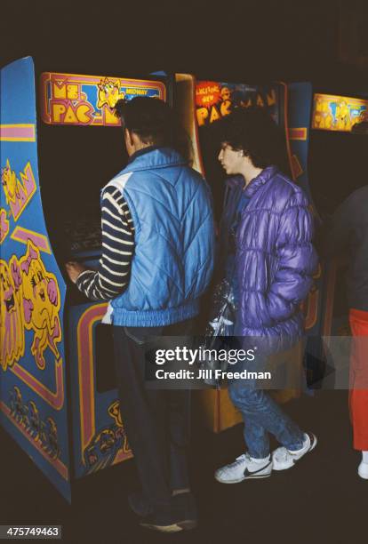 Couple playing arcade games, namely Ms Pac-Man, New York City, circa 1985.