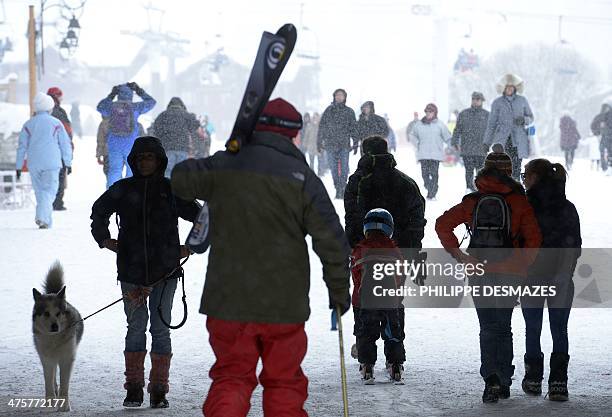 People walk in the snow at the French Alps Val d'Isere ski resort, on March 1, 2014. The ski area of Val d'Isère and Tignes forms the Espace Killy,...