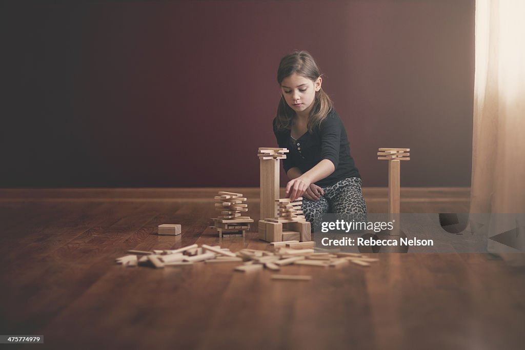 Girl building with wooden blocks