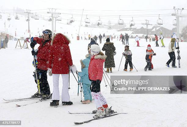 People stand in the snow as others are skiing at the French Alps Val d'Isere ski resort, on March 1, 2014 during France's school holydays. The ski...
