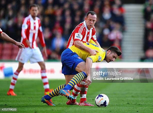 Olivier Giroud of Arsenal battles with Charlie Adam of Stoke City during the Barclays Premier League match between Stoke City and Arsenal at...