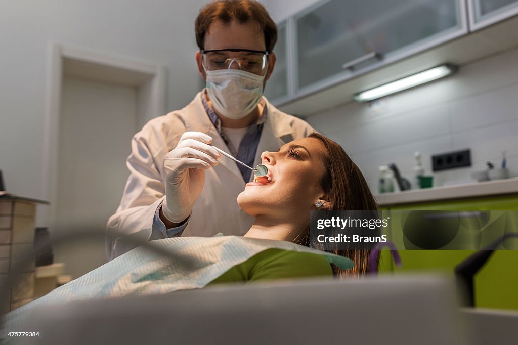 Woman having dental appointment at male dentist.