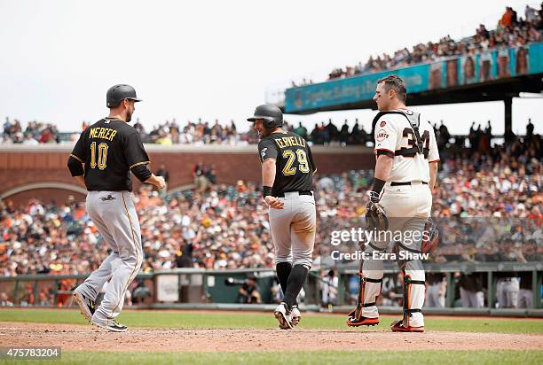 Francisco Cervelli looks back at Jordy Mercer of the Pittsburgh Pirates as they run past catcher Andrew Susac of the San Francisco Giants after they...