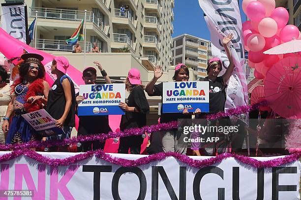 People stand on a float holding signs saying 'Love Uganda, hate homophobia' in reaction to Uganda's law banning homosexuality. Hundreds of people...