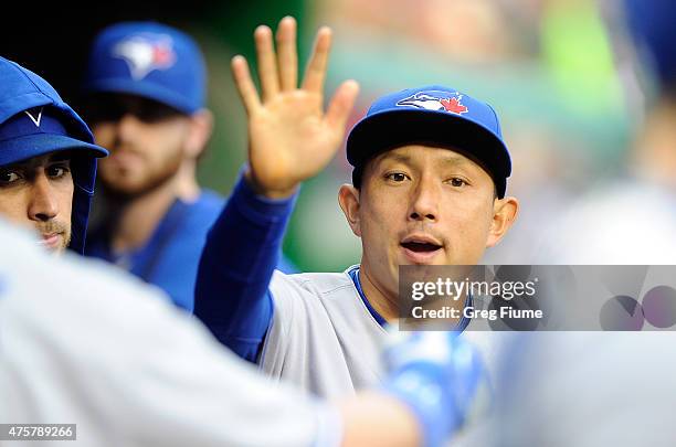 Munenori Kawasaki of the Toronto Blue Jays celebrates with teammates after a Blue Jays run in the first inning against the Washington Nationals at...