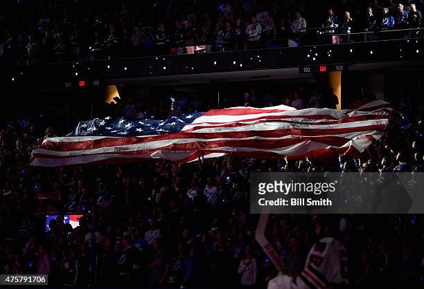 The American flag is seen in the crowd during the singing of the national anthem prior to the Chicago Blackhawks taking on the Tampa Bay Lightning in...