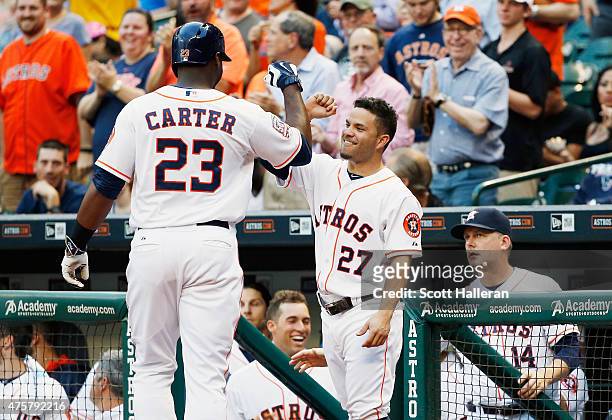 Chris Carter of the Houston Astros is greeted by teammate Jose Altuve after Carter hit a solo home run off Miguel Gonzalez of the Baltimore Orioles...