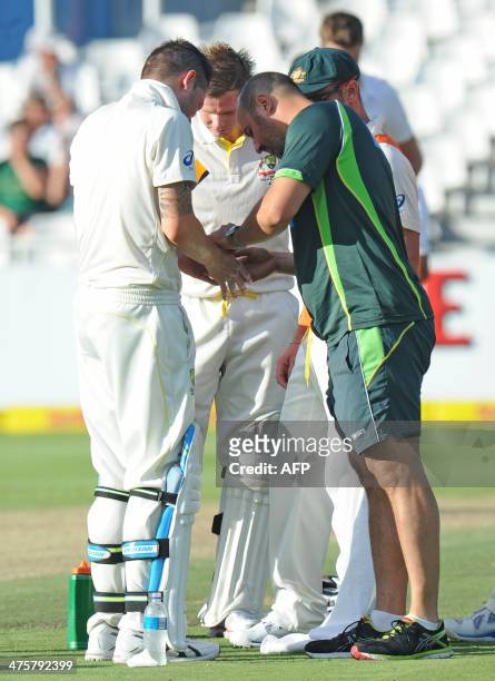 Michael Clarke of Australia is treated for an injury on day 1 of the third Test match between South Africa and Australia at Newlands in Cape Town on...