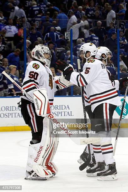 Corey Crawford and David Rundblad of the Chicago Blackhawks celebrate after defeating the Tampa Bay Lightning 2-1 in Game One of the 2015 NHL Stanley...