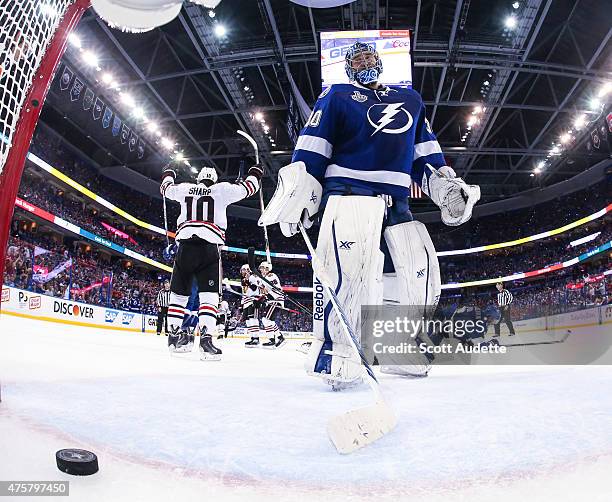 Goalie Ben Bishop of the Tampa Bay Lightning reacts to a goal while Patrick Sharp of the Chicago Blackhawks celebrates during the third period in...