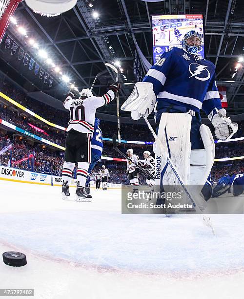 Goalie Ben Bishop of the Tampa Bay Lightning reacts to a goal while Patrick Sharp of the Chicago Blackhawks celebrates during the third period in...