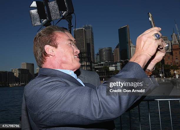 Arnold Schwarzenegger and Jai Courtney take a selfie during a 'Terminator Genisys' photo call at the Park Hyatt Sydney on June 4, 2015 in Sydney,...