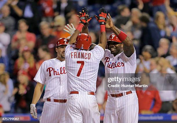 Maikel Franco of the Philadelphia Phillies high fives Jeff Francoeur and Ryan Howard after hitting a game tying three-run home run in the ninth...