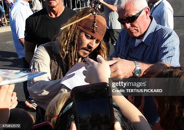 Hollywood actor Johnny Depp , dressed as Captain Jack Sparrow from the Pirates of the Caribbean film franchise, signs autographs for fans after...