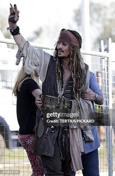 Hollywood actor Johnny Depp , dressed as Captain Jack Sparrow from the Pirates of the Caribbean film franchise, waves to fans after a day on the film...
