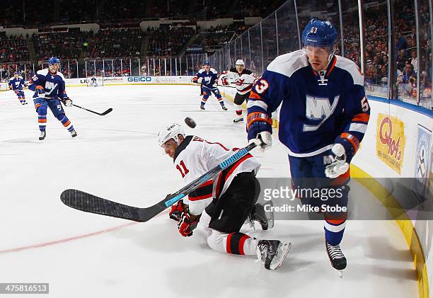 Casey Cizikas of the New York Islanders battles for the puck with Stephen Gionta of the New Jersey Devils at Nassau Veterans Memorial Coliseum on...