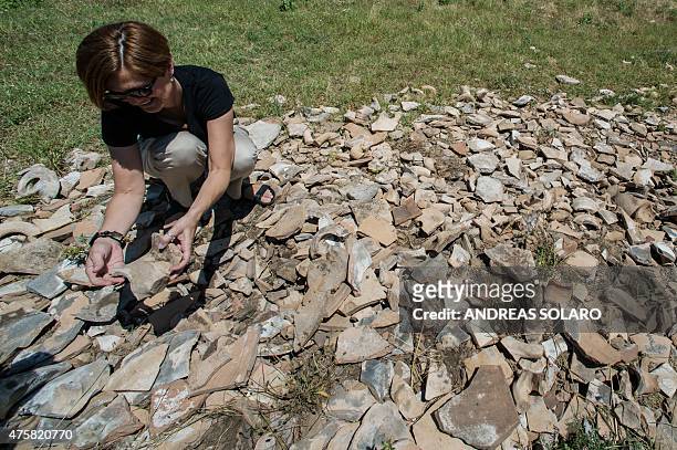 Woman holds pieces of ancient amphorae at Monte di Coccio alias Monte Testaccio , in Rome on June 3, 2015. Composed of the remains of some 25 million...