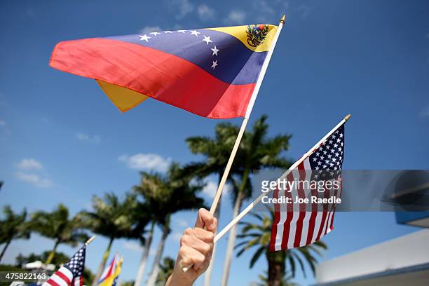 Protester holds a Venezuelan and American flag as she and other Venezuelans and their supporters show their support for the anti-government protests...