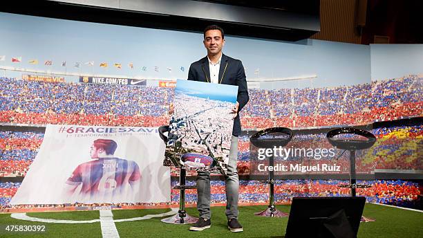 Xavi Hernandez poses with a gift from the club during the 'FC Barcelona Homage to Xavi' ahead of his final game for the club at Camp Nou on June 3,...