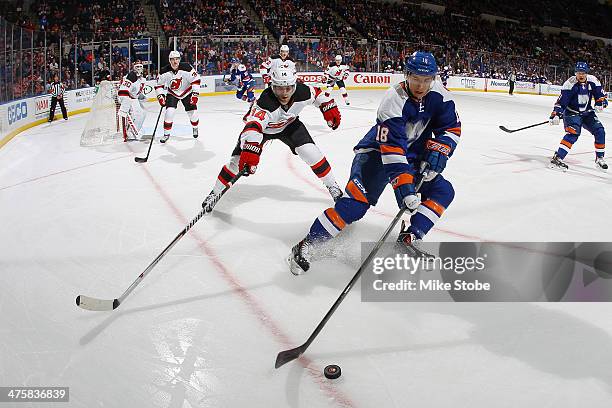 Ryan Strome of the New York Islanders skates with the puck as Adam Henrique of the New Jersey Devils pursues him at Nassau Veterans Memorial Coliseum...