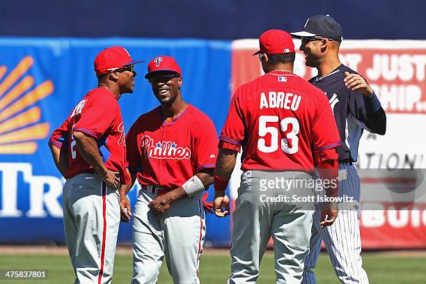 Derek Jeter of the New York Yankees chats with Ben Revere, Reid Brignac and Bobby Abreu of the Philadelphia Phillies before a spring training game at...