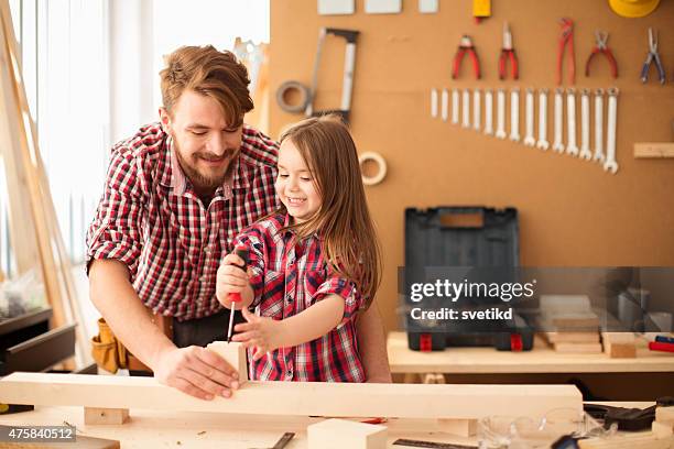 father with his cute little daughter in woodshop. - workshop tools stock pictures, royalty-free photos & images