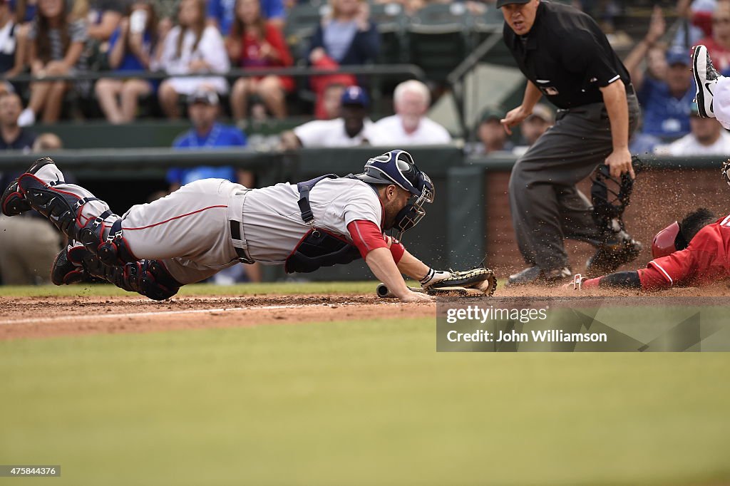 Catcher Sandy Leon of the Boston Red Sox dives to tag the baserunner ...