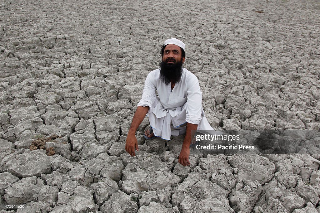 A farmer at cracked land looking to the sky hoping for...