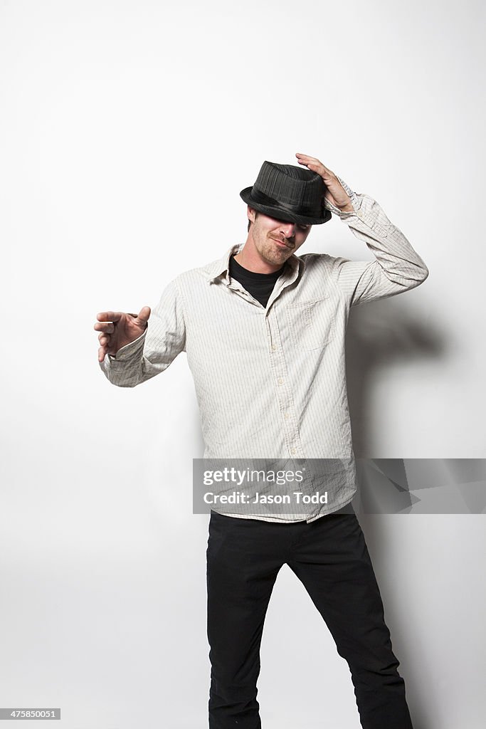 Man on white tipping hat and dancing