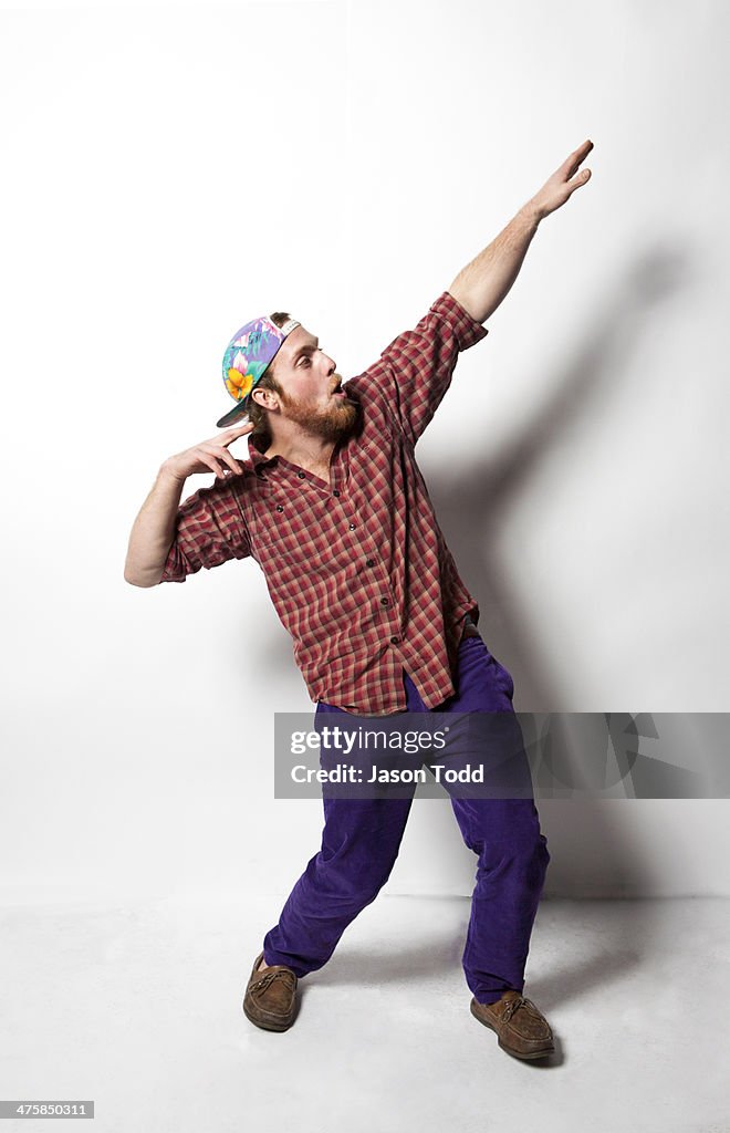 Man doing Greek God pose in colorful clothes