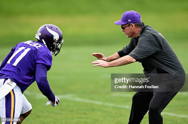 Head coach Mike Zimmer of the Minnesota Vikings blocks Mike Wallace during a drill at practice on June 4, 2015 at Winter Park in Eden Prairie,...