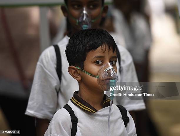 School children of Suraj Memorial High School wears an oxygen masks to raise awareness regarding the dangers of air pollution on the eve of World...